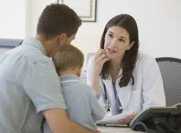 A father and son talking with a doctor in a consulting room