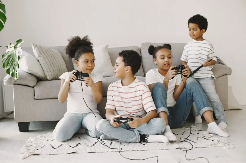 Four children playing video games together in a cozy living room setting