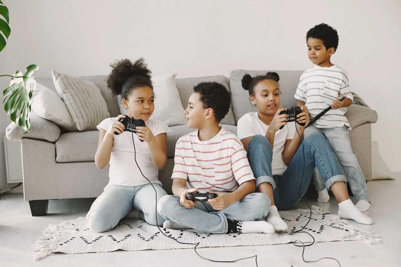Four children playing video games together in a cozy living room setting