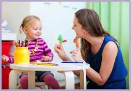 A therapist and a toddler playing with toys at a table