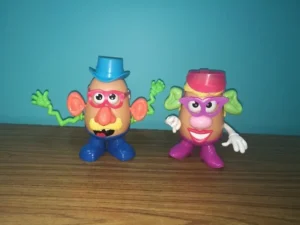 Two Mr Potato Head toys standing on a wooden floor