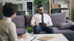 Man having a therapy session with a psychologist in a cozy office environment