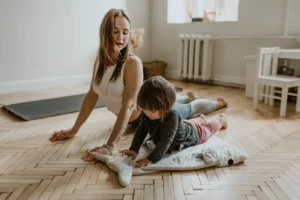 A mother and child practicing yoga together at home on a sunny day, fostering wellness and connection