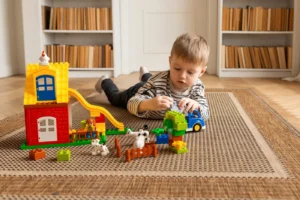 Young boy engaged in imaginative block play on a carpeted floor indoors