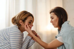Two women comfort each other, depicting empathy and support in an intimate setting