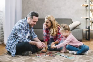 Happy family playing with puzzle pieces with daughter