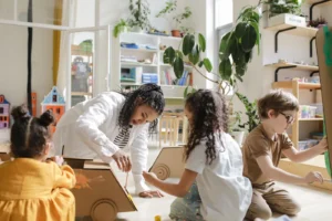 Children engaging in a creative art project with a teacher in a classroom