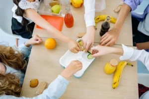 Children enjoying a variety of healthy snacks and drinks at a shared table, top view