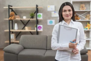 Friendly female psychologist standing her office with clipboard pencil