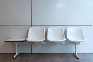 A minimalist setup of white plastic waiting room chairs in a modern interior