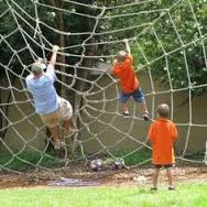 Children climbing a rope net in a playground